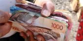 a hand holding kenya bank notes